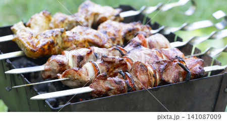 Grilling delicious shashlik on mangal during backyard gathering in warm weather Grilling delicious shashlik on mangal during backyard gathering in warm weather 141087009