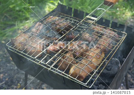 Enjoying shashlik on a mangal grill during a weekend outdoor gathering 141087015