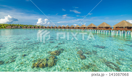 Stunning Maldives turquoise ocean bay lagoon, overwater villas, luxury resort paradise. Exotic tropical island, romantic summer honeymoon escape. Relaxing travel destination background wallpaper Stunning Maldives turquoise ocean bay lagoon, overwater villas, luxury resort paradise. Exotic tropical island, romantic summer honeymoon escape. Relaxing travel destination background wallpaper 141087068