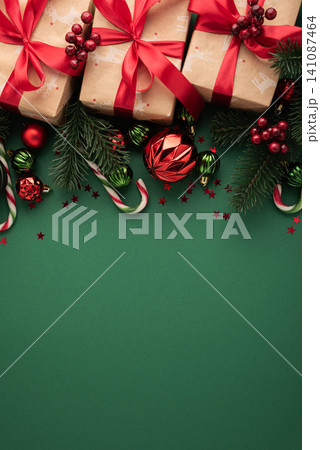 Christmas gifts and decorations on green background creating holiday frame for copy space Christmas gifts and decorations on green background creating holiday frame for copy space 141087464