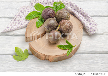 Purple passion fruit with leaves on wooden board Purple passion fruit with leaves on wooden board 141087964