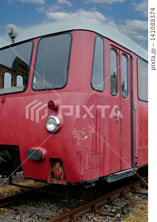 Close up of an old red railcar cabin with a headlight on rusty tracks Close up of an old red railcar cabin with a headlight on rusty tracks 141088374