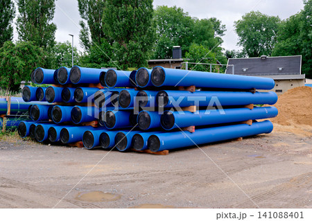 Heavy duty blue plastic industrial pipelines stacked on ground 141088401