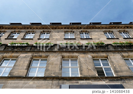 Low angle view of a classic stone building facade with flower boxes on windows 141088438
