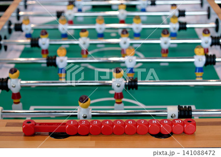 Close up of table football score counter with blurred foosball players background Close up of table football score counter with blurred foosball players background 141088472