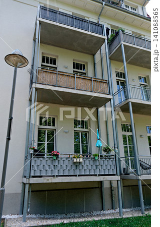 Apartment building facade with modern balconies and flowers on a sunny day Apartment building facade with modern balconies and flowers on a sunny day 141088565
