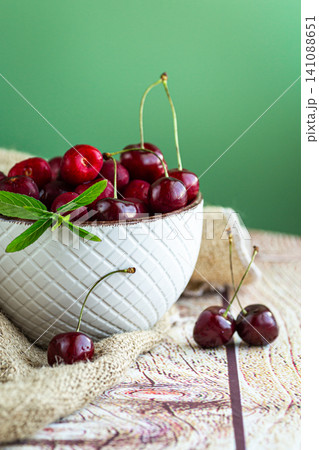 Organic fresh cherries with mint on natural wooden surface Organic fresh cherries with mint on natural wooden surface 141088651