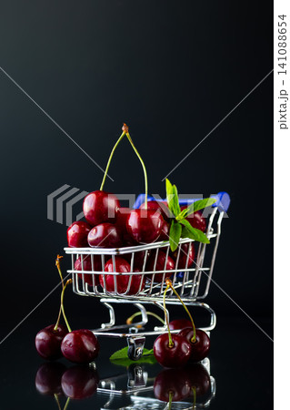 Organic fresh cherries displayed in miniature grocery shopping cart 141088654
