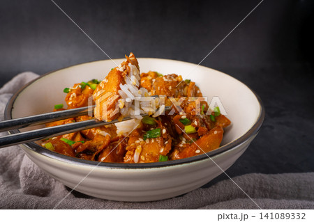 In chopsticks with Delicious sweet chopping chicken rice, sesame seeds and sliced spring onions, broccoli, vegetables in bowl Asian food, Japanese food 141089332