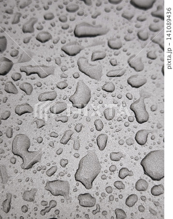 Close-up of raindrops on the glossy surface of a car. Close-up of raindrops on the glossy surface of a car. 141089436