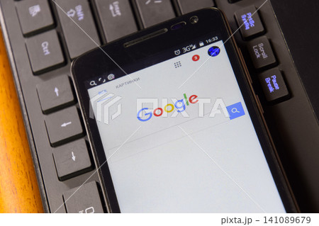Smartphone with Google search system on the keyboard background. Smartphone with Google search system on the keyboard background. 141089679
