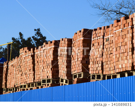 Red bricks stacked into cubes. Warehouse bricks. Storage brickworks products Red bricks stacked into cubes. Warehouse bricks. Storage brickworks products 141089831