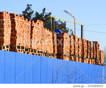 Red bricks stacked into cubes. Warehouse bricks. Storage brickworks products Red bricks stacked into cubes. Warehouse bricks. Storage brickworks products 141089832