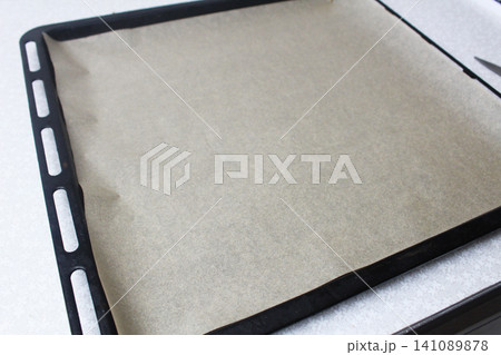 The baking sheet is covered with baking paper. Preparation for cooking The baking sheet is covered with baking paper. Preparation for cooking 141089878
