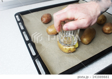 Male cook Crispy smashed potatoes in the oven Male cook Crispy smashed potatoes in the oven 141089881