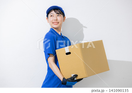 荷物を運ぶ笑顔の女性ドライバー 荷物を運ぶ笑顔の女性ドライバー 141090135