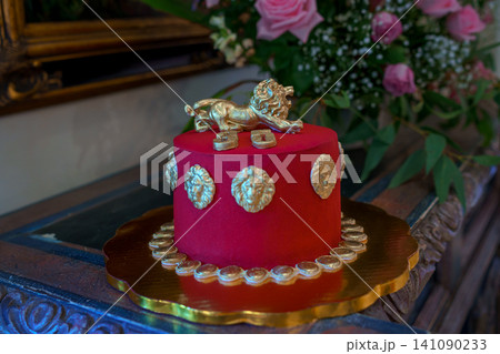 Red velvet cake with golden lion and coin decorations 141090233