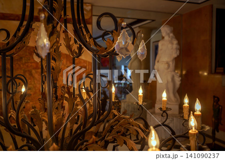 Ornate chandelier with glowing candles and crystal details 141090237
