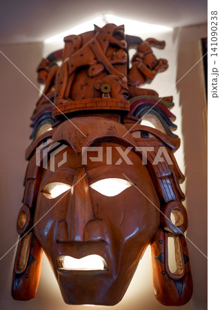 Intricate wooden mask with detailed carvings and headdress 141090238