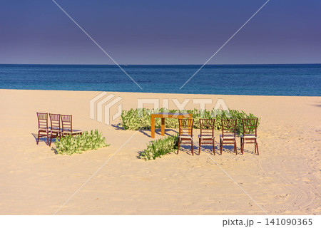 Beach wedding ceremony setup with chairs and flowers Beach wedding ceremony setup with chairs and flowers 141090365