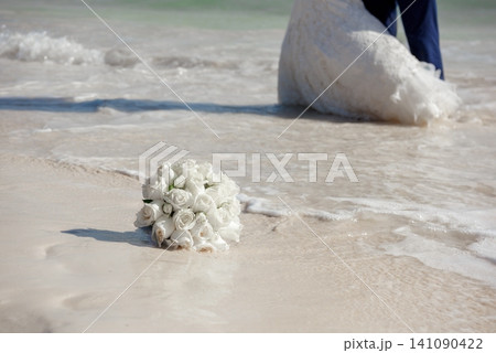 White rose bouquet on wet sandy beach White rose bouquet on wet sandy beach 141090422