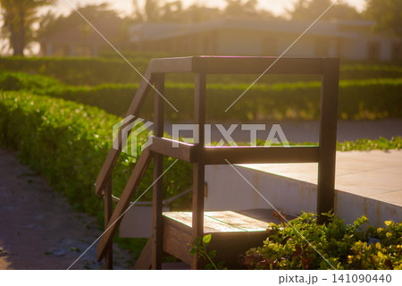 Wooden pool ladder glowing in warm afternoon sunlight Wooden pool ladder glowing in warm afternoon sunlight 141090440