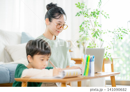 勉強する小学生と働くママ 勉強する小学生と働くママ 141090682