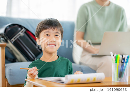 勉強する小学生と働くママ 勉強する小学生と働くママ 141090688