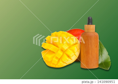 Fresh mango slices and essential oil bottle showcase tropical flavors Fresh mango slices and essential oil bottle showcase tropical flavors 141090951
