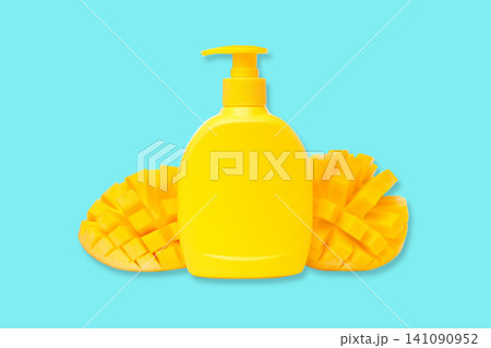 Bright yellow bottle resembles ripe mango with fresh mango slices beside it Bright yellow bottle resembles ripe mango with fresh mango slices beside it 141090952