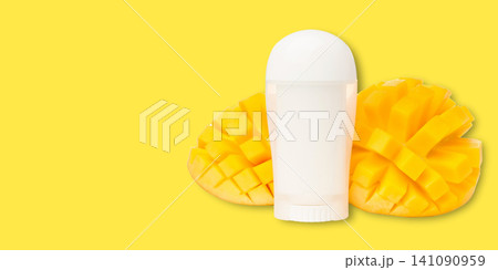 Stick deodorant showcased with vibrant mango halves. Unique product presentation concept Stick deodorant showcased with vibrant mango halves. Unique product presentation concept 141090959