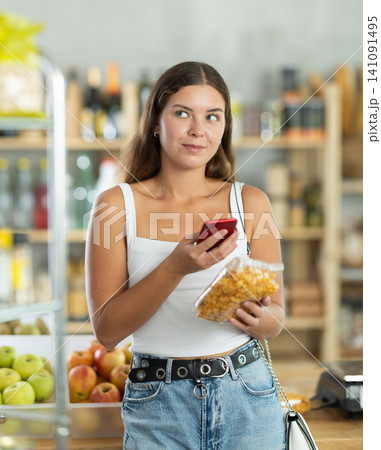 Young woman scanning qr code of corn flakes Young woman scanning qr code of corn flakes 141091495