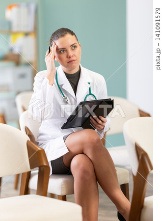 Puzzled and surprised young girl medical student sitting and listening lecture, taking notes on tablet in auditory or lecture hall Puzzled and surprised young girl medical student sitting and listening lecture, taking notes on tablet in auditory or lecture hall 141091579