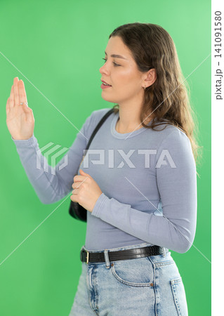 Young woman moves her finger across virtual screen Young woman moves her finger across virtual screen 141091580