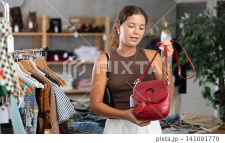 Woman choosing handbags in the store 141091770