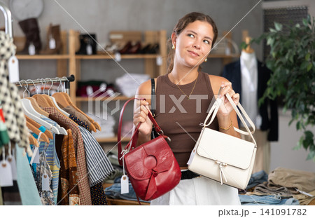 Woman choosing handbags in the store Woman choosing handbags in the store 141091782