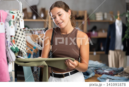 woman chooses a scarf and a handkerchief around her neck woman chooses a scarf and a handkerchief around her neck 141091878