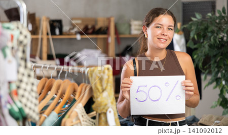 Woman holding a poster with a discount Woman holding a poster with a discount 141092012