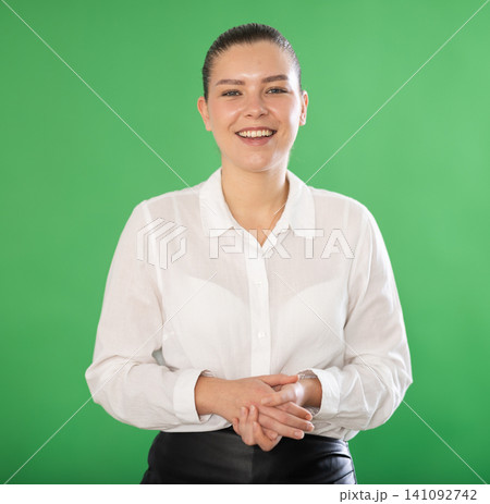European woman stands against a green background European woman stands against a green background 141092742