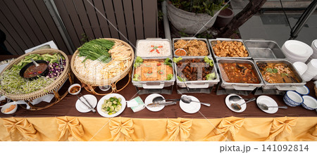 A vibrant selection of Asian food is displayed at a street food court, featuring Thai specialties, salad, vegetables, and freshly prepared traditional dishes. A vibrant selection of Asian food is displayed at a street food court, featuring Thai specialties, salad, vegetables, and freshly prepared traditional dishes. 141092814