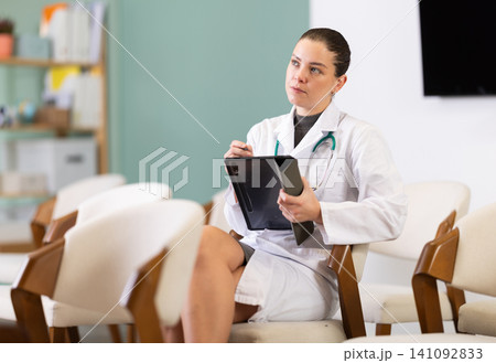 Young woman medical student takes notes on tablet Young woman medical student takes notes on tablet 141092833