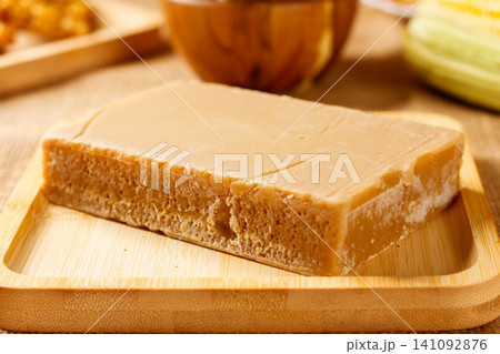 Homemade Brazilian rapadua, a sweet made from concentrated sugarcane juice, presented on a bamboo tray with a rustic aesthetic. A traditional Brazilian confection. Homemade Brazilian rapadua, a sweet made from concentrated sugarcane juice, presented on a bamboo tray with a rustic aesthetic. A traditional Brazilian confection. 141092876