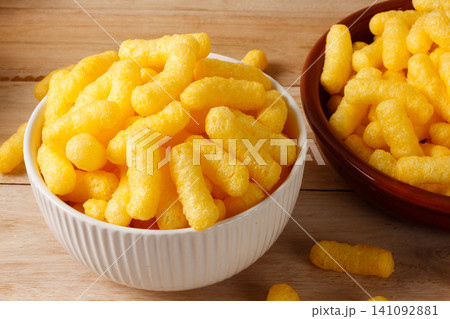 Crispy corn sticks in ceramic bowls on a light wood table Crispy corn sticks in ceramic bowls on a light wood table 141092881