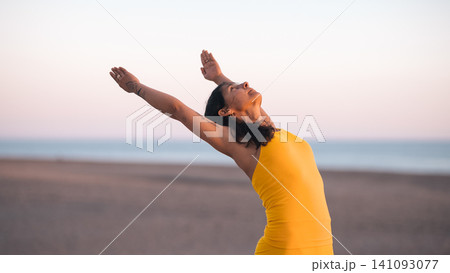 Woman practicing yoga stretching on beach during sunset Woman practicing yoga stretching on beach during sunset 141093077