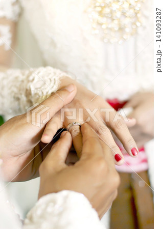 Wedding Rings on the Fingers of the Bride and Groom For Marriage, Love, Wedding Ceremony And Romantic Celebration symbolizing eternal love, commitment, trust, and the beginning of a lifelong journey Wedding Rings on the Fingers of the Bride and Groom For Marriage, Love, Wedding Ceremony And Romantic Celebration symbolizing eternal love, commitment, trust, and the beginning of a lifelong journey 141093287