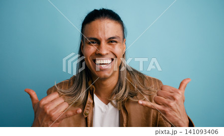 Happy latino man making shaka sign gesture Happy latino man making shaka sign gesture 141093406