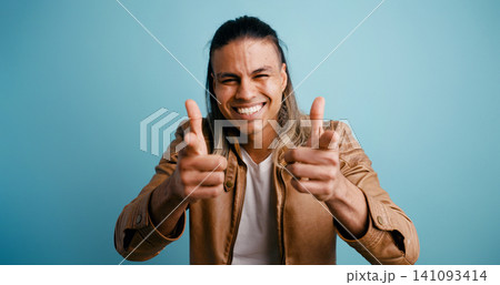 Latino man smiling making finger guns gesture Latino man smiling making finger guns gesture 141093414