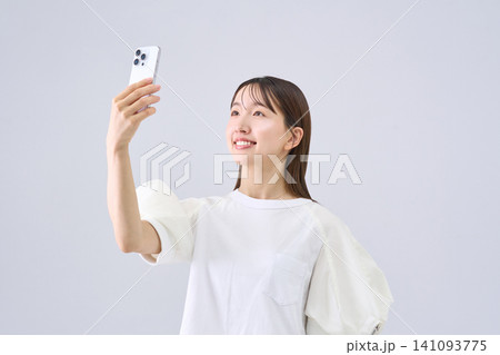 スマートフォンを見上げる日本人女性 スマートフォンを見上げる日本人女性 141093775