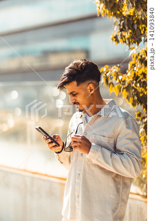 Moroccan man using smartphone outdoors in city Moroccan man using smartphone outdoors in city 141093840