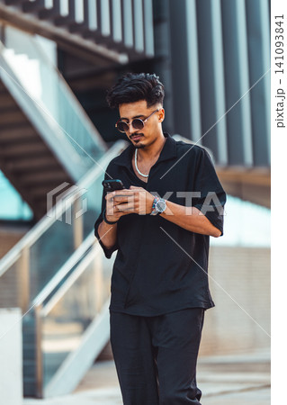 Moroccan man using smartphone in urban setting 141093841